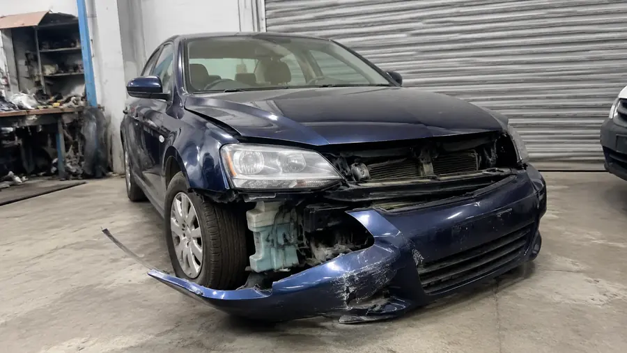 Cracked front bumper cover and crushed absorber on a sedan in Dallas