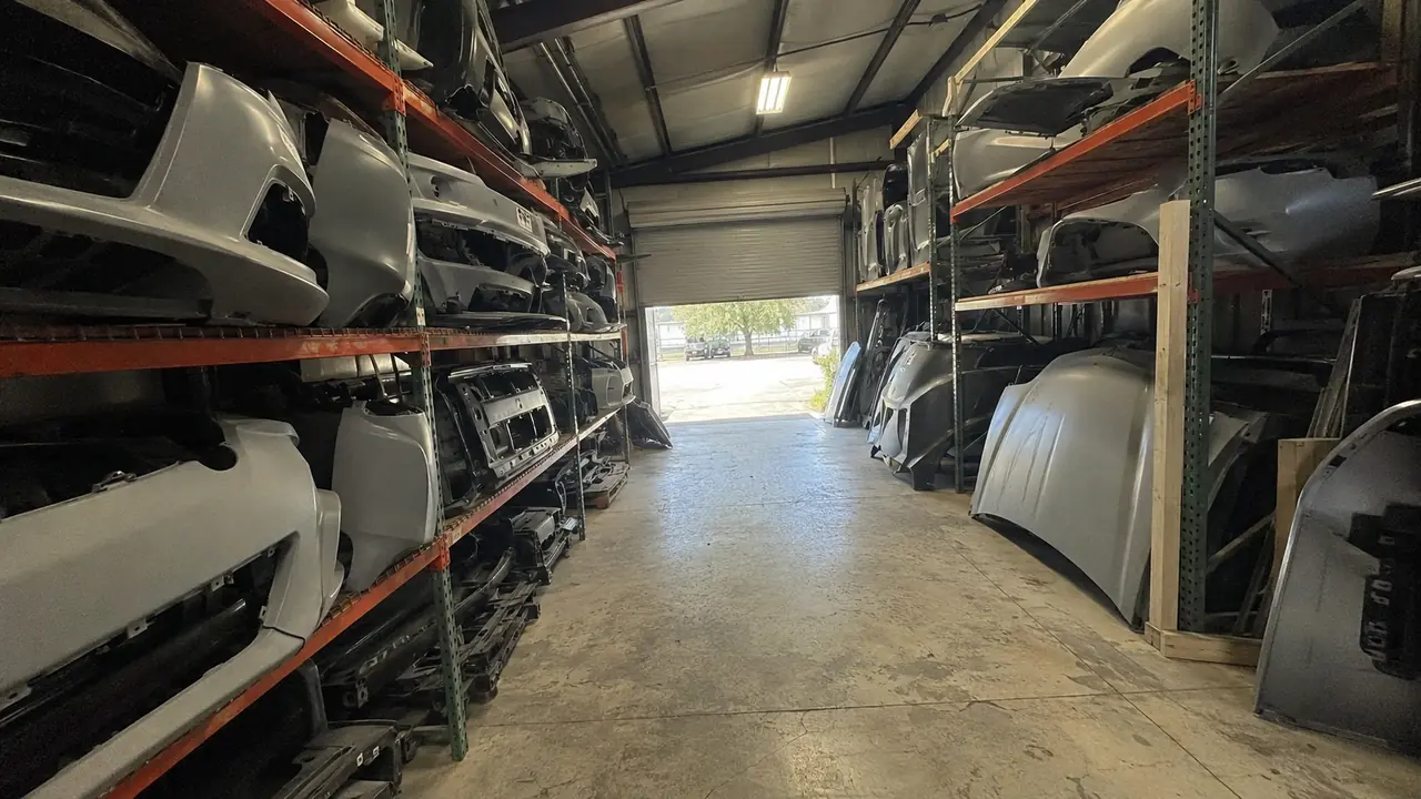 Aftermarket bumper covers and fenders racked at an auto car parts store in Dallas